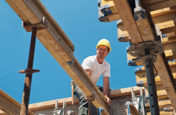 Trabalhador da construção que coloca vigas de cofragem — Fotografia de Stock