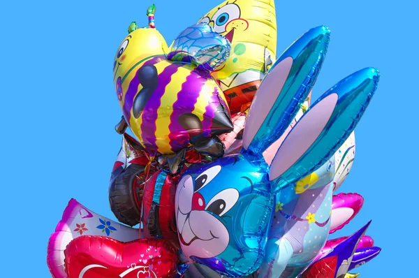Balony latające w postaci zabawek na białym tle niebieski niebo — Zdjęcie stockowe
