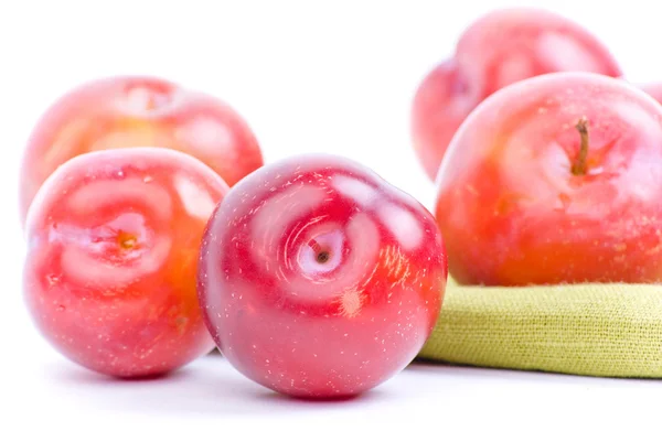 Red plums on green textile — Stock Photo, Image