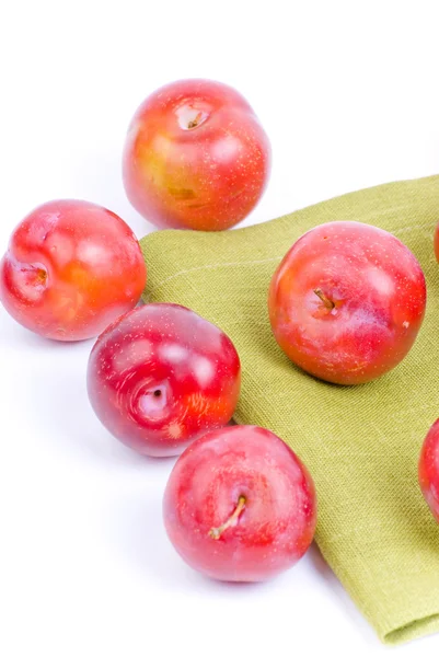 Red plums on green textile — Stock Photo, Image