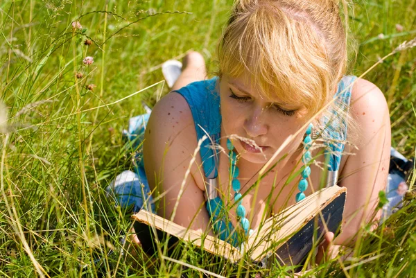Fille dans l'herbe avec livre — Photo