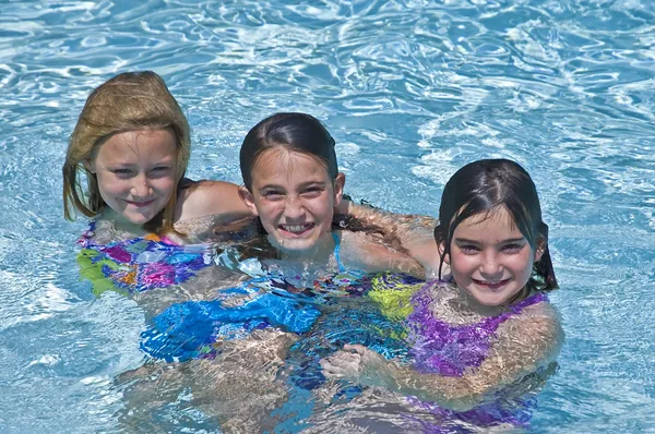 Três meninas bonitos em uma piscina — Fotografia de Stock