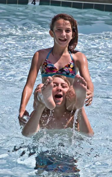 Menino e menina brincando na piscina — Fotografia de Stock