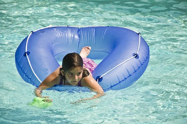 Jong meisje op tube in zwembad — Stockfoto