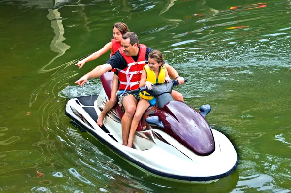 Man och döttrar på jet ski pekar — Stockfoto