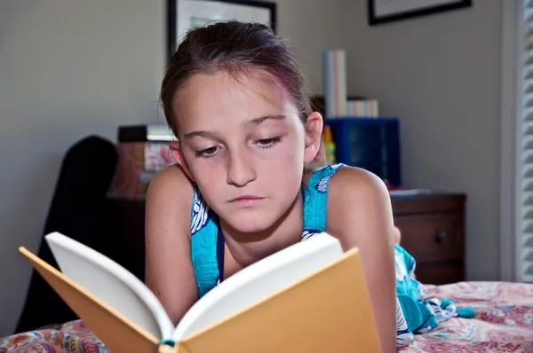 Jong meisje het lezen van een boek in haar kamer — Stockfoto