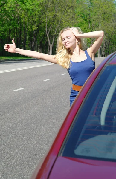 Dívka blondýna hlasuje o červeném autě, v létě, Moskva — Stock fotografie