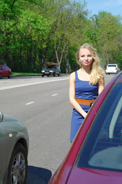 La chica la rubia sobre el coche rojo es trastornada por la rotura del coche, la muchacha, la rubia — Foto de Stock