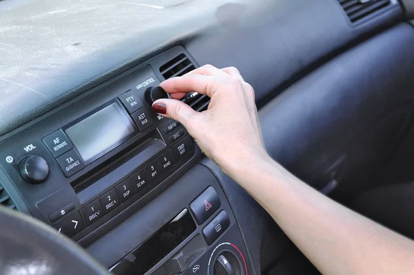 The female hand presses buttons in salon of the car in the summer — Stock Photo, Image