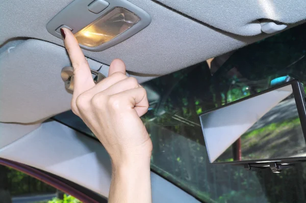 Den kvindelige hånd trykker på knapper i salonen af bilen om sommeren - Stock-foto