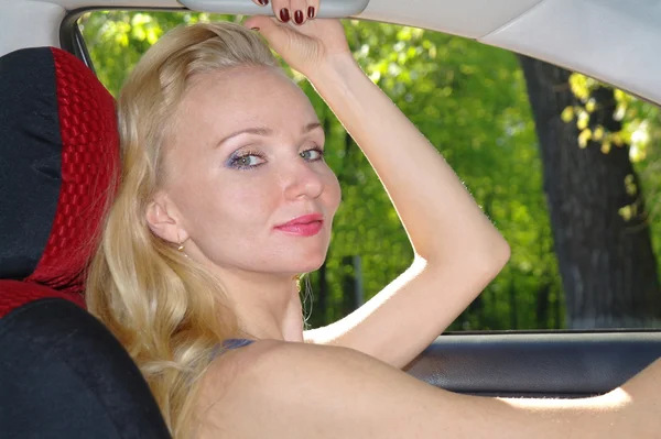 La ragazza la bionda al volante l'auto in estate — Foto Stock