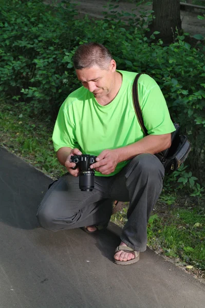 O homem que o fotógrafo senta e olha para a câmera — Fotografia de Stock