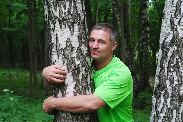 Adam bir huş ağacı kucaklayan — Stok fotoğraf