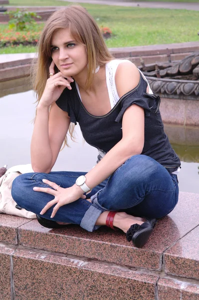 Thoughtful girl sitting by the fountain, Moscow — Stock Photo, Image