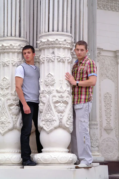 Двоє молодих чоловіків, оточених білими колонами — стокове фото