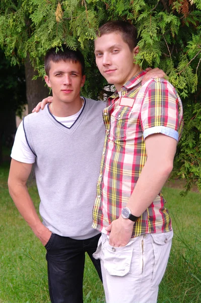 Porträt zweier junger Männer unter einem Ast — Stockfoto