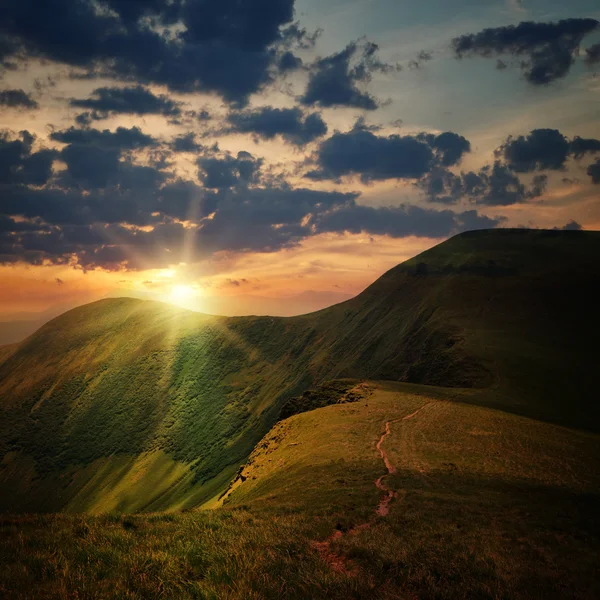 Pico da colina com caminho e pôr do sol da montanha — Fotografia de Stock