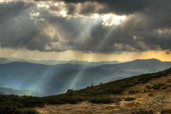 Облака и солнечные лучи в горах — стоковое фото