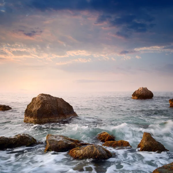 Auringonnousu kallioisella rannikolla — kuvapankkivalokuva