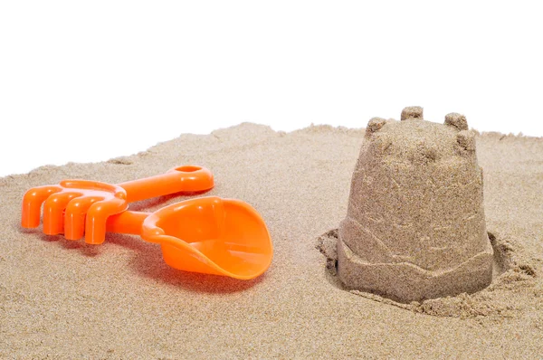 Shovel, rake and sandcastle — Stock Photo, Image