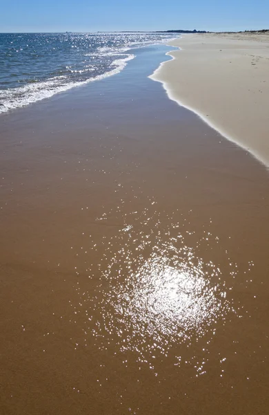 Reflection of the sun on the water over the sand — Stock Photo, Image