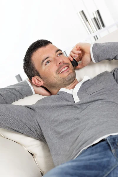 Hombre telefoneando en sofá — Foto de Stock
