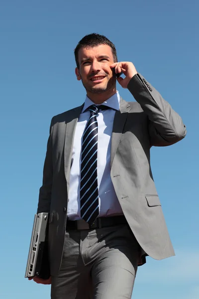 Businessman on the phone in blue sky — Stock Photo, Image