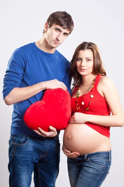 Zadowolony mężczyzna i kobieta w ciąży z czerwonym sercem — Zdjęcie stockowe