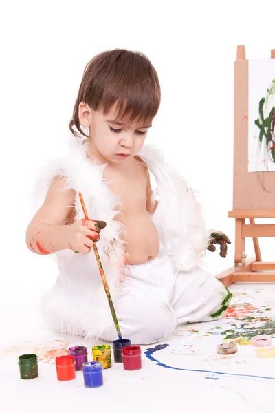 Милая детская живопись с кистью возле мольберта — стоковое фото