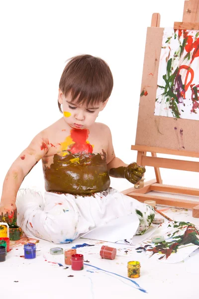 Funny dirty child choosing paints — Stock Photo, Image