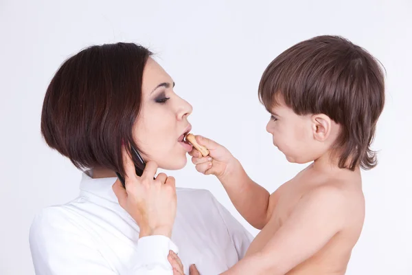 Child feed his mother with cookies — Stock Photo, Image