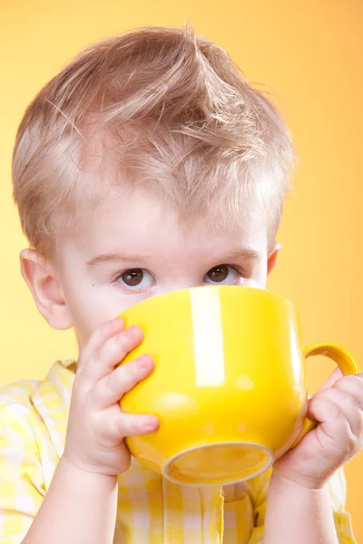 Funny boy drink from big yellow cup — Stock Photo, Image