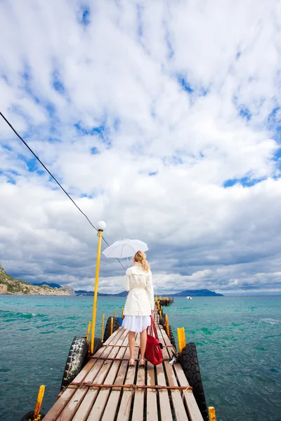 Mujer caminando en la pasarela del mar — Foto de Stock