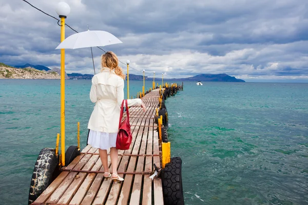 Mujer caminando en la pasarela del mar — Foto de Stock