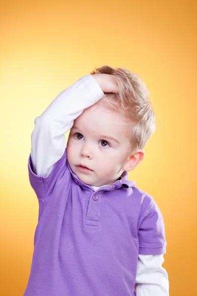 Disturbed little boy holding head with hand — Stock Photo, Image