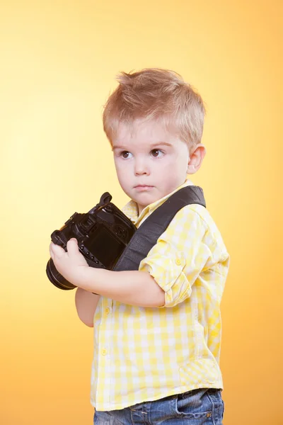Pequeno fotógrafo mostrar câmera profissional — Fotografia de Stock