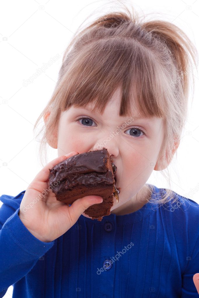 Hungry little girl eating cake