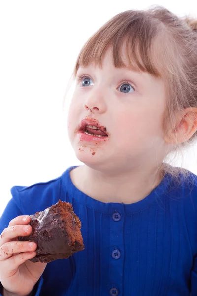Überrascht kleines Mädchen, das Schokoladenkuchen isst — Stockfoto