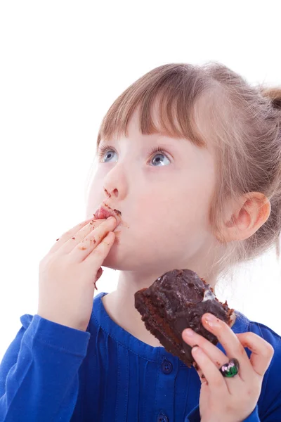 Fome engraçado menina lamber dedos sujo com saboroso bolo — Fotografia de Stock