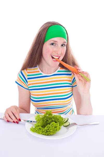 Улыбающаяся женщина ест морковь и салат — стоковое фото