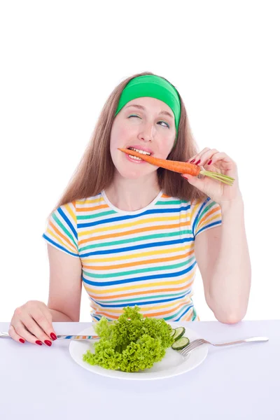 Мечтательная женщина ест морковь и салат — стоковое фото