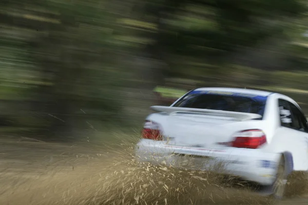 Белый гоночный автомобиль брызгает грязь — стоковое фото
