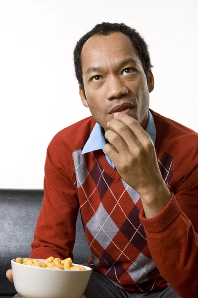 stock image Man nibbling while watching television