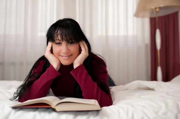 stock image Woman reading a book in bed