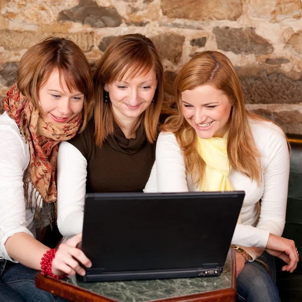 Three beautiful young students waiting for coffee and checking n — Stock Photo, Image