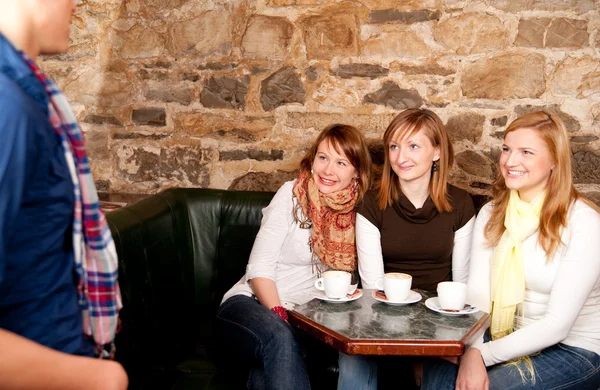 El hombre acaba de llegar en un café donde tres chicas estaban esperando hola — Foto de Stock