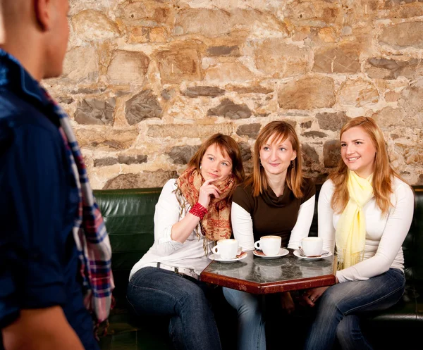 O homem acabou de chegar a um café onde três meninas estavam esperando oi — Fotografia de Stock