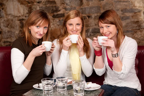 Three beautiful young students waiting drinking coffee and havi — Stock Photo, Image