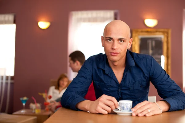 Giovane uomo che beve caffè nel caffè — Foto Stock