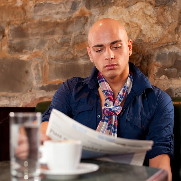 Mladý muž pije kávu v kavárně — Stock fotografie